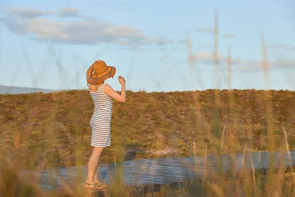 A girl walking along a wooden path to the beach - Foto, imagen