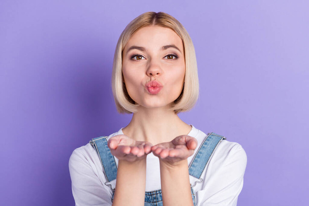 Photo of cute optimistic short hairdo blond lady blow kiss wear white t-shirt isolated on violet color background - Photo, image