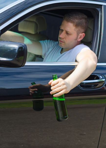 οδήγηση υπό την επήρεια. αρσενικό χέρι με μπουκάλι μπύρας. - Φωτογραφία, εικόνα