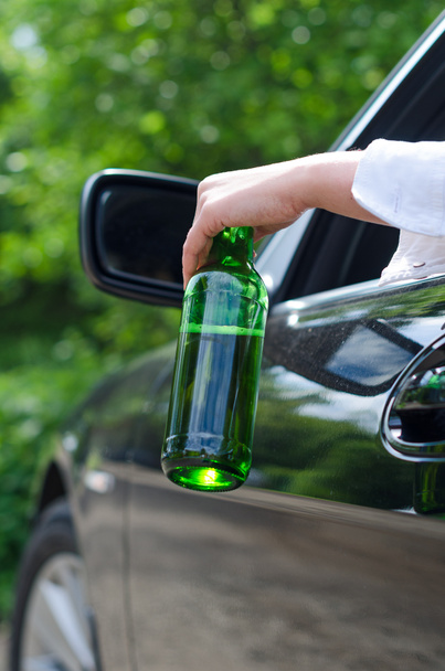 Fahren unter Alkoholeinfluss. weibliche Hand mit Flasche Bier. - Foto, Bild