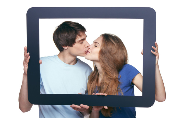 In love couple holding tablet frame kissing - Фото, изображение
