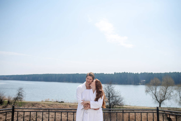 A couple in white bathrobes enjoying the morning in a countryside house - Foto, afbeelding