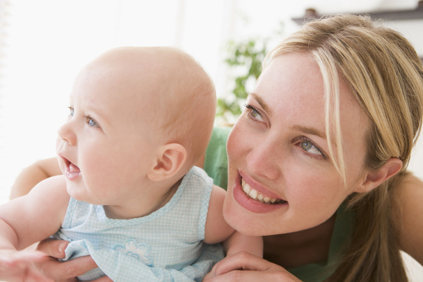 Mother in living room with baby smiling - Foto, Bild