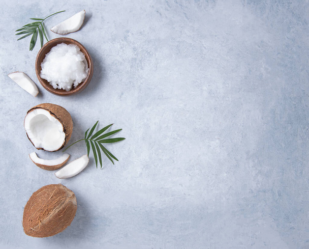 Eco friendly flat lay. Fresh coconut oil and coconut slices  on blue  background. Healthy and vegan food. Top view and copy space image - Photo, Image