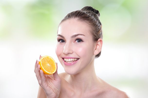 Beautiful woman face with orange - Фото, зображення