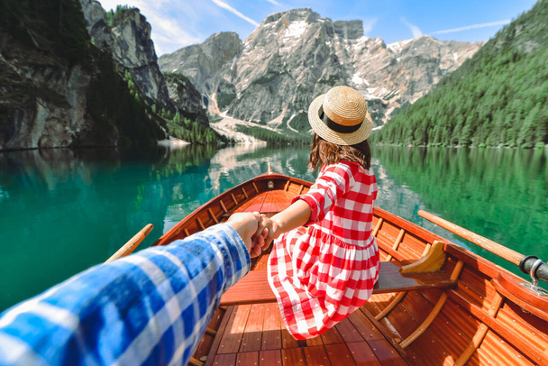 sledovat můj koncept. pár držící se za ruce na dřevěné lodi u horského jezera. letní cestovní koncept - Fotografie, Obrázek