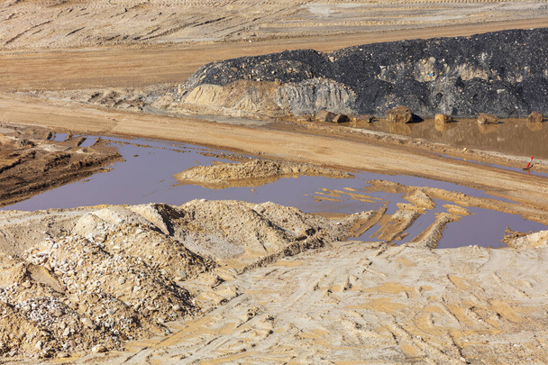 Photograph of stagnant flood water lying on the ground in a large quarry - Photo, Image