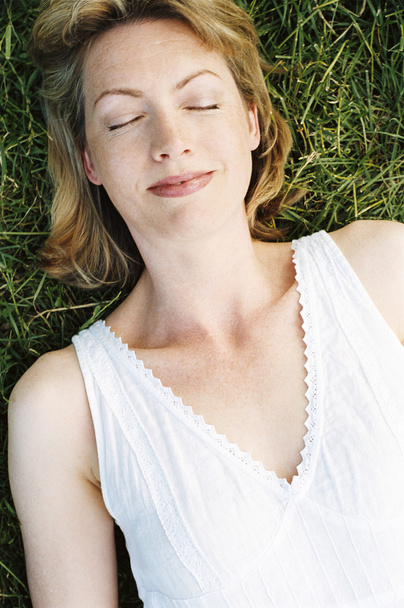 Woman lying outdoors sleeping - Foto, afbeelding
