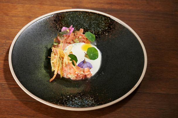Chopped tartar meat with white sauce and eatable flowers - 写真・画像