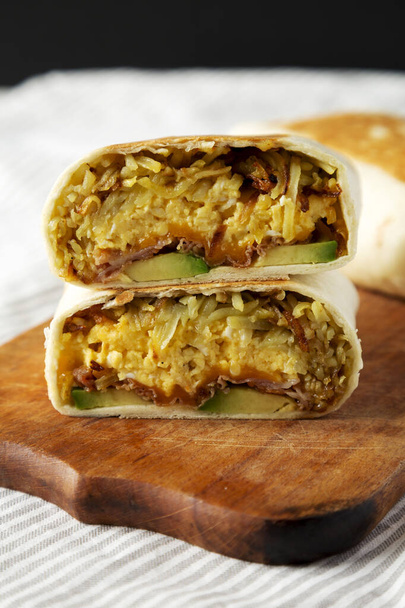 Homemade Breakfast Egg Burrito with Avocado and Bacon on a rustic wooden board, side view. Close-up. - Фото, зображення