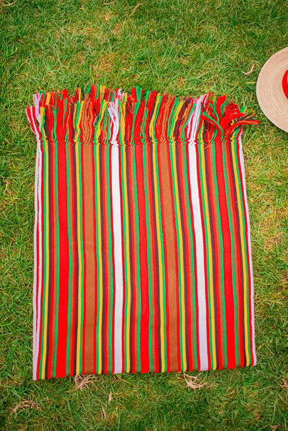 背景に草のある赤いマヤの美しい典型的な織物 - 写真・画像