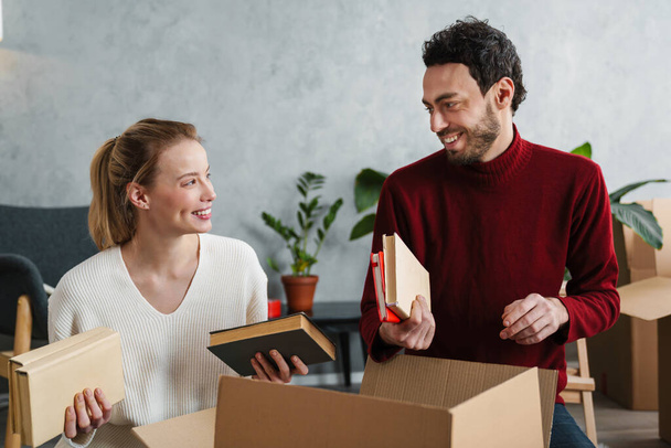 Attractive young couple moving to a new house, unpacking - Foto, Imagem