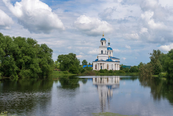 Εκκλησία της Μεσολάβησης της Αγιωτάτης Θεοτόκου στην ακτή μιας λίμνης στο χωριό Γλούχωβο της Ρωσίας. - Φωτογραφία, εικόνα