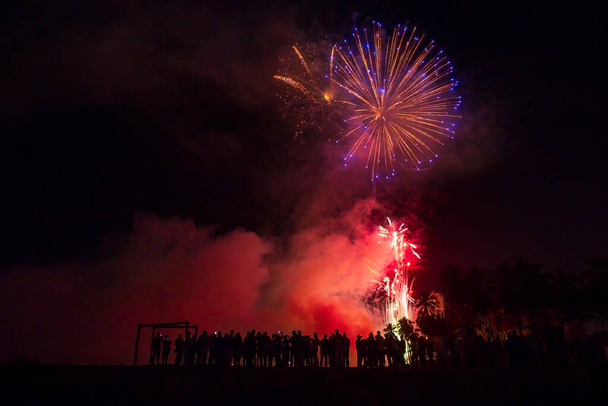 A tömeg az emberek nézi a színes tűzijáték ünneplés megjelenítése - Fotó, kép