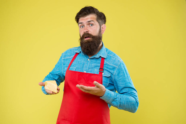 would you try this. choose online shopping. Gourmet product. puzzled bearded man hold cheese. cheesemaking techniques. cheese maker. hipster with beard in chef apron. Dairy food shop - Fotoğraf, Görsel