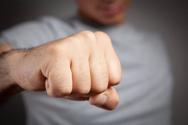 man shows fist on gray background - Photo, Image