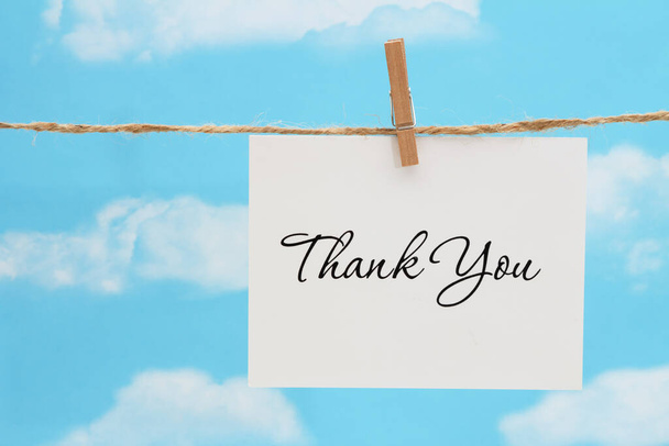 Thank you white greeting card over hanging clear blue sky - Photo, Image