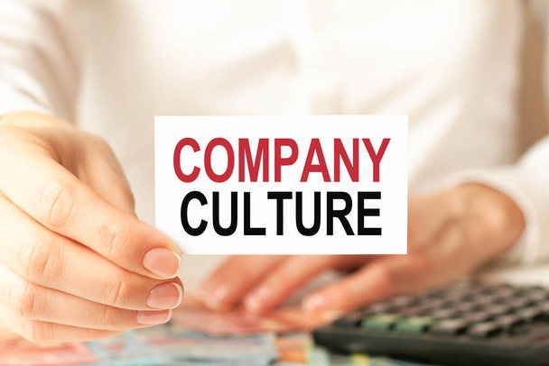 a woman in a white shirt holds a piece of paper with the text: company culture. Business concept. - 写真・画像