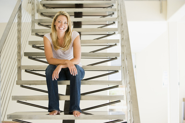 Woman sitting on stairs smiling - Фото, зображення