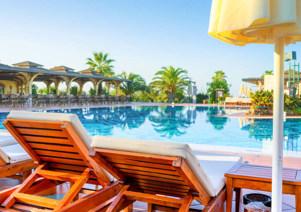 Lege ligbedden en zwembad in luxe resort - Foto, afbeelding