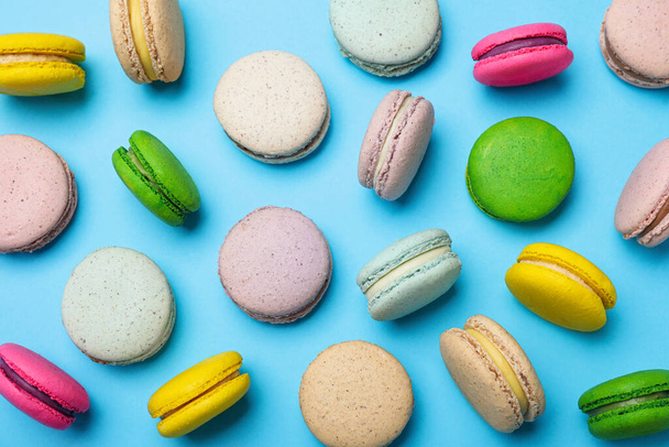 Delicious colorful macarons on light blue background, flat lay - Photo, Image