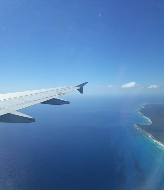 Vista sul sedile del finestrino della coda dell'aereo in cielo blu con nuvole  - Foto, immagini