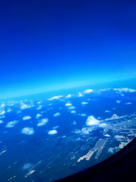 Window seat view of airplane  tail in blue sky with clouds  - Photo, Image