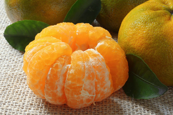 Detalle de mandarina pelada sobre fondo rústico - Foto, imagen