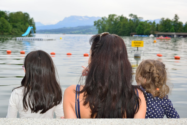 Maman et les filles contemplant un lac
 - Photo, image