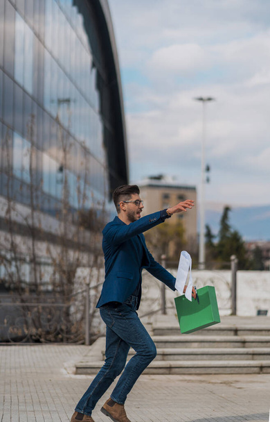 Young businessman with a folder and glasses running in a city street on a background of glass office building - Foto, immagini