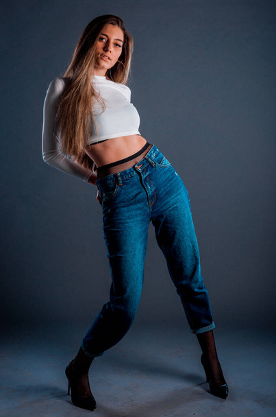 Studio body shot di una giovane donna alla moda che indossa pantaloni e maglione in stile moderno - Foto, immagini
