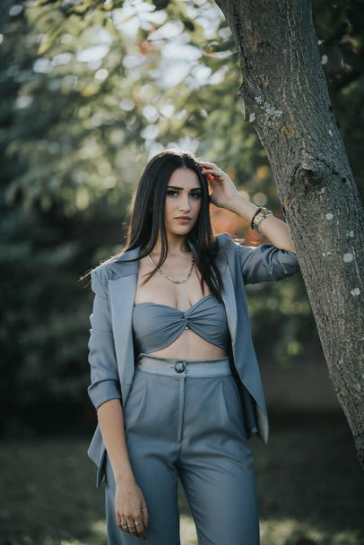 A sexy female from Bosnia and Herzegovina in a trendy blue suit posing in the forest - 写真・画像
