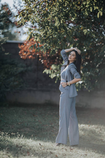 A shallow focus of an adult woman wearing a gray suit with a crop top in a garden - Φωτογραφία, εικόνα