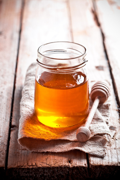 full honey pot and honey stick - Фото, зображення