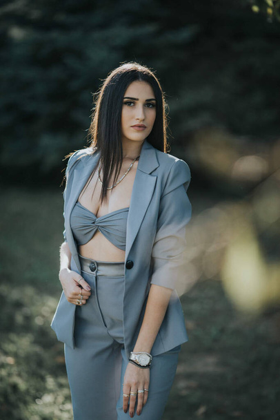A young sexy Caucasian girl in a grey suit posing in the garden - Photo, image