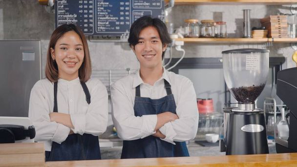 Portrait of happy handsome young man and beautiful woman confident cafe owner standing crossed arms on front counter bar together at the cafe coffee shop, Owner small business concept - Foto, immagini