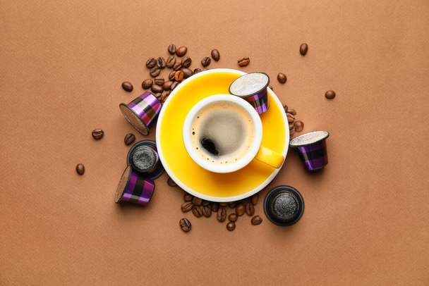 Taza de café, cápsulas y frijoles sobre fondo de color - Foto, Imagen
