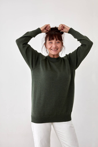Mujer madura feliz en suéter verde cálido - Foto, imagen