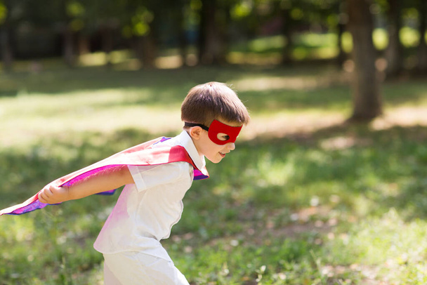 mały chłopiec w stroju Superhero zabawy na świeżym powietrzu w letni słoneczny dzień  - Zdjęcie, obraz
