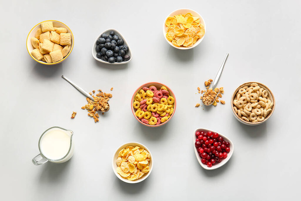 Composizione con diversi cereali, bacche e latte su fondo chiaro - Foto, immagini