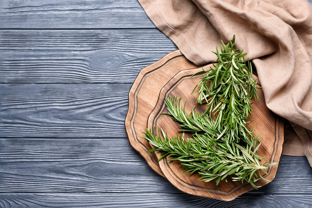 Boards with fresh rosemary on dark wooden background - 写真・画像