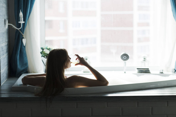 a young woman resting bath of foam and drinks wine. lifestyle. Day spa.  - Zdjęcie, obraz