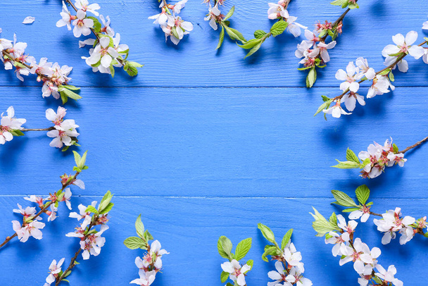 Рамка з красивих квітучих гілок на кольоровому дерев'яному фоні
 - Фото, зображення