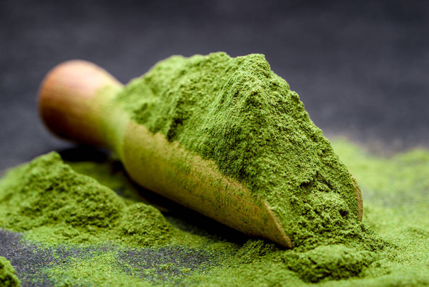 Green tea, matcha. Powdered young barley or wheat grass on wooden scoop. Detox superfood concept. - Foto, immagini