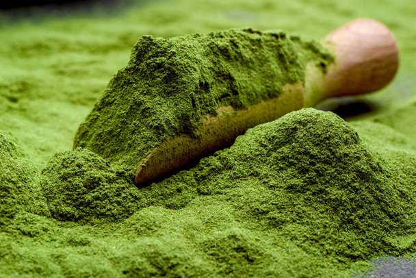 Green tea, matcha. Powdered young barley or wheat grass on wooden scoop. Detox superfood concept. - Фото, зображення