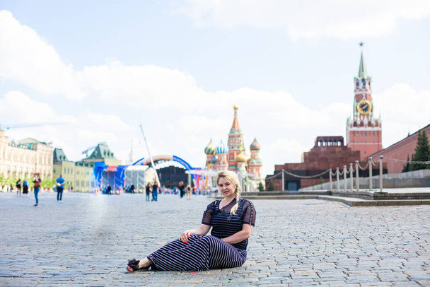 Happy young woman lying on Red Square - Fotoğraf, Görsel