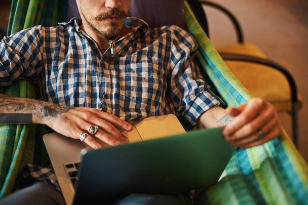 Bearded young man using modern laptop at home - Fotó, kép