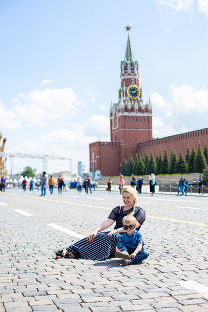 Happy young woman and son lying on Red Square - Photo, Image