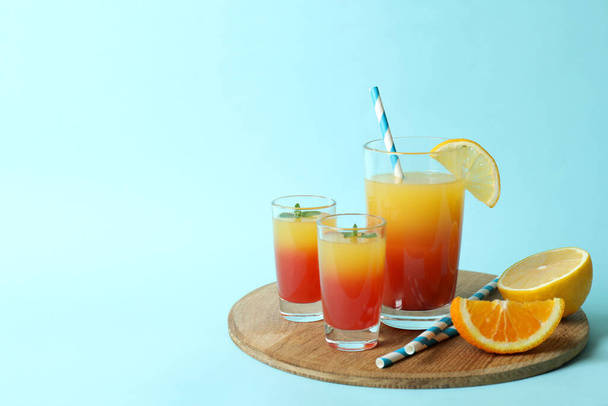 Board with Tequila sunrise cocktail on blue background - Photo, image