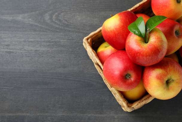 Basket with red apples on dark wooden table - Photo, Image